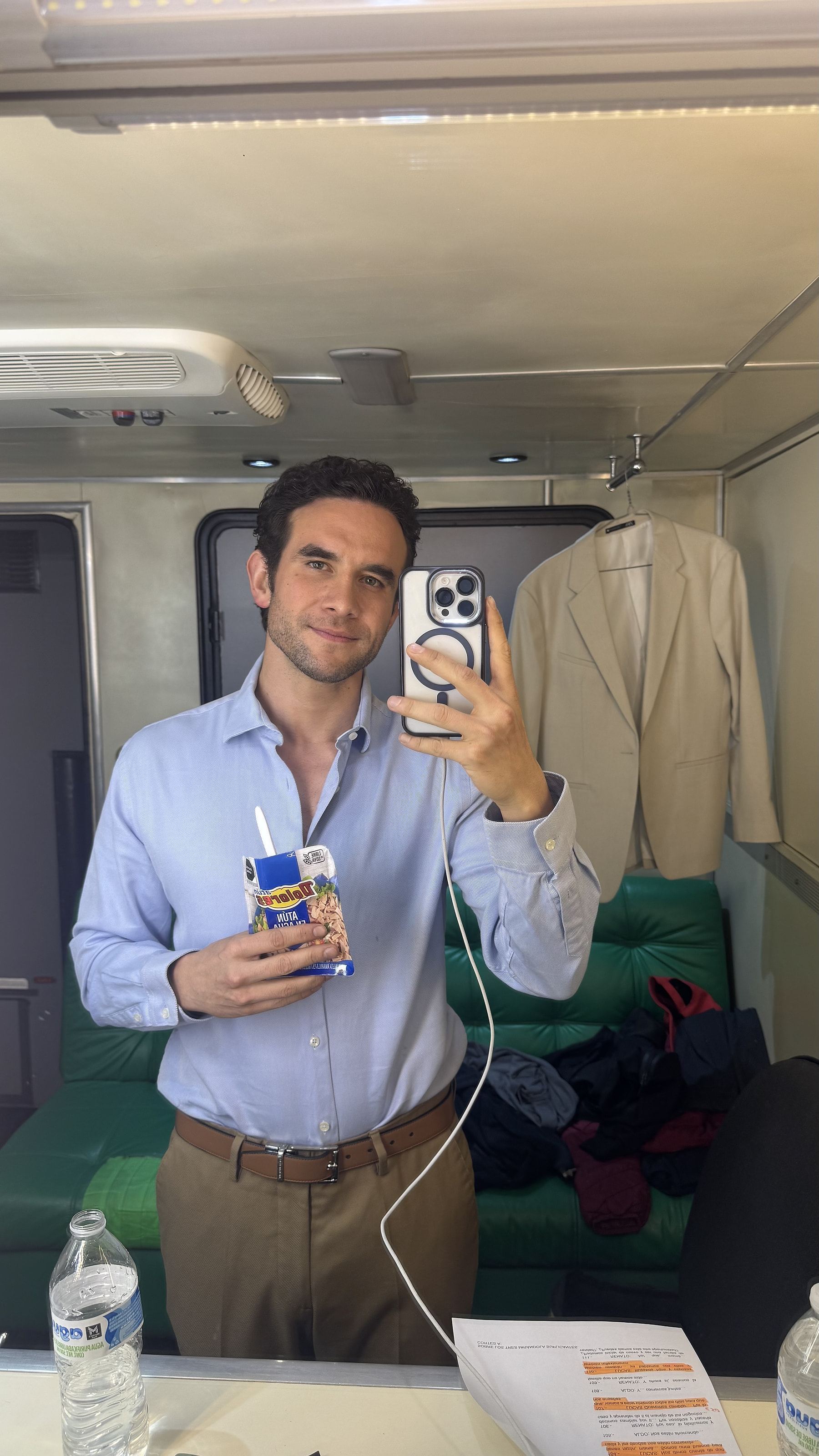 Marco Valdés con camisa azul claro en un camerino, tomándose una foto en el espejo